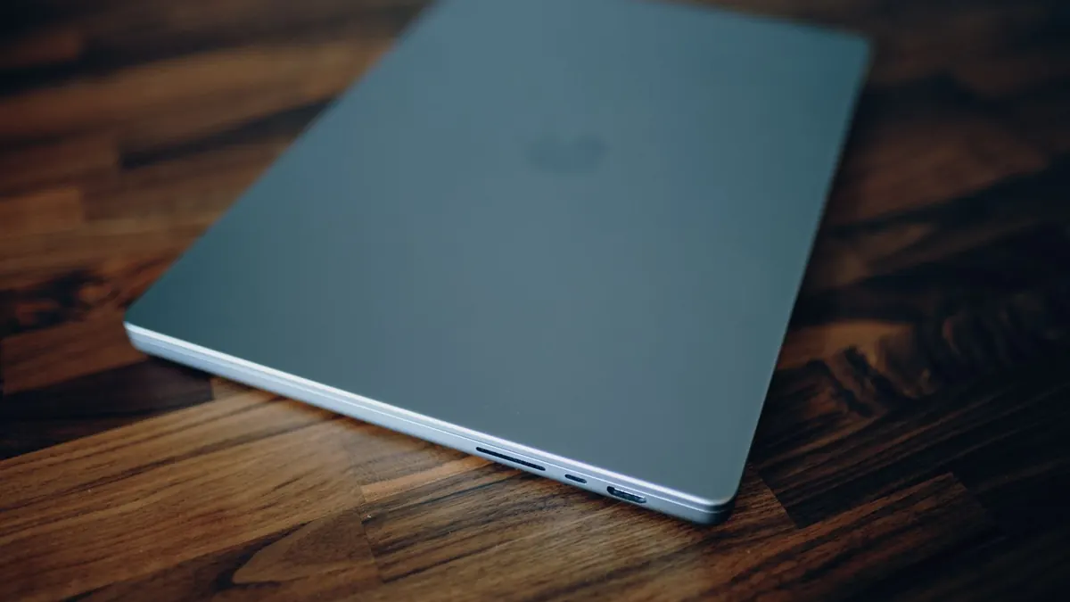 A closed laptop on a dark wooden table