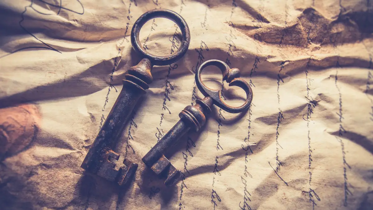 Two old iron keys resting on handwritten paper