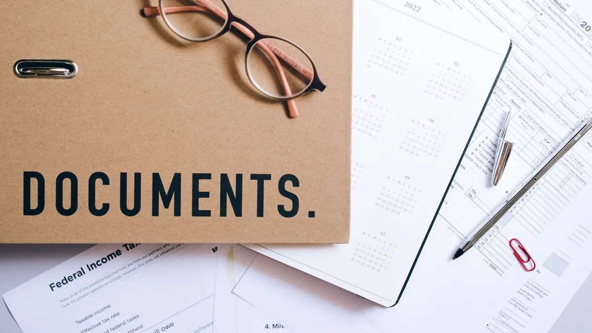 A folder marked Documents with papers and a pair of glasses