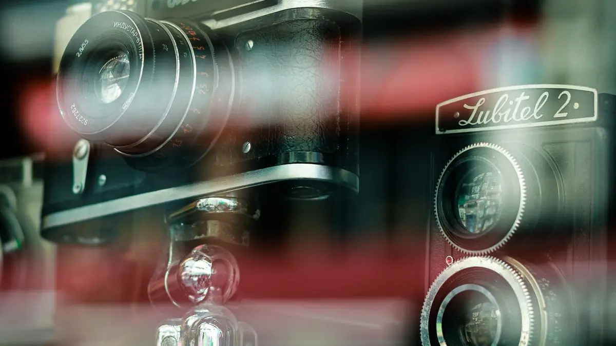 A vintage film camera displayed behind glass