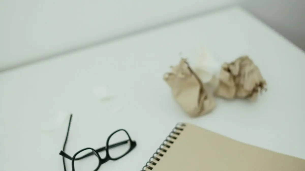 Reading glasses resting beside a notebook on a desk